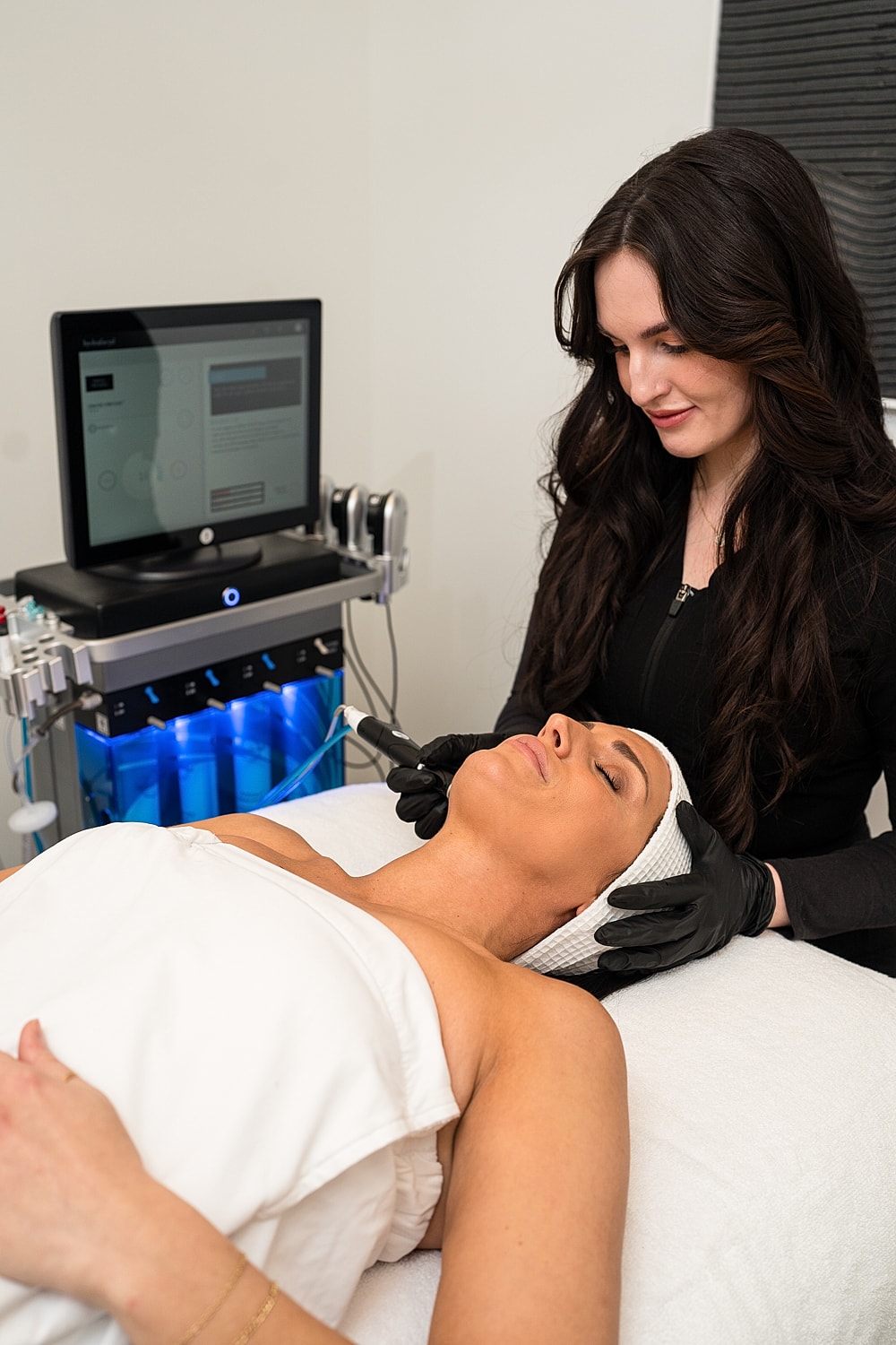 Woman receiving skin treatment in spa setting.