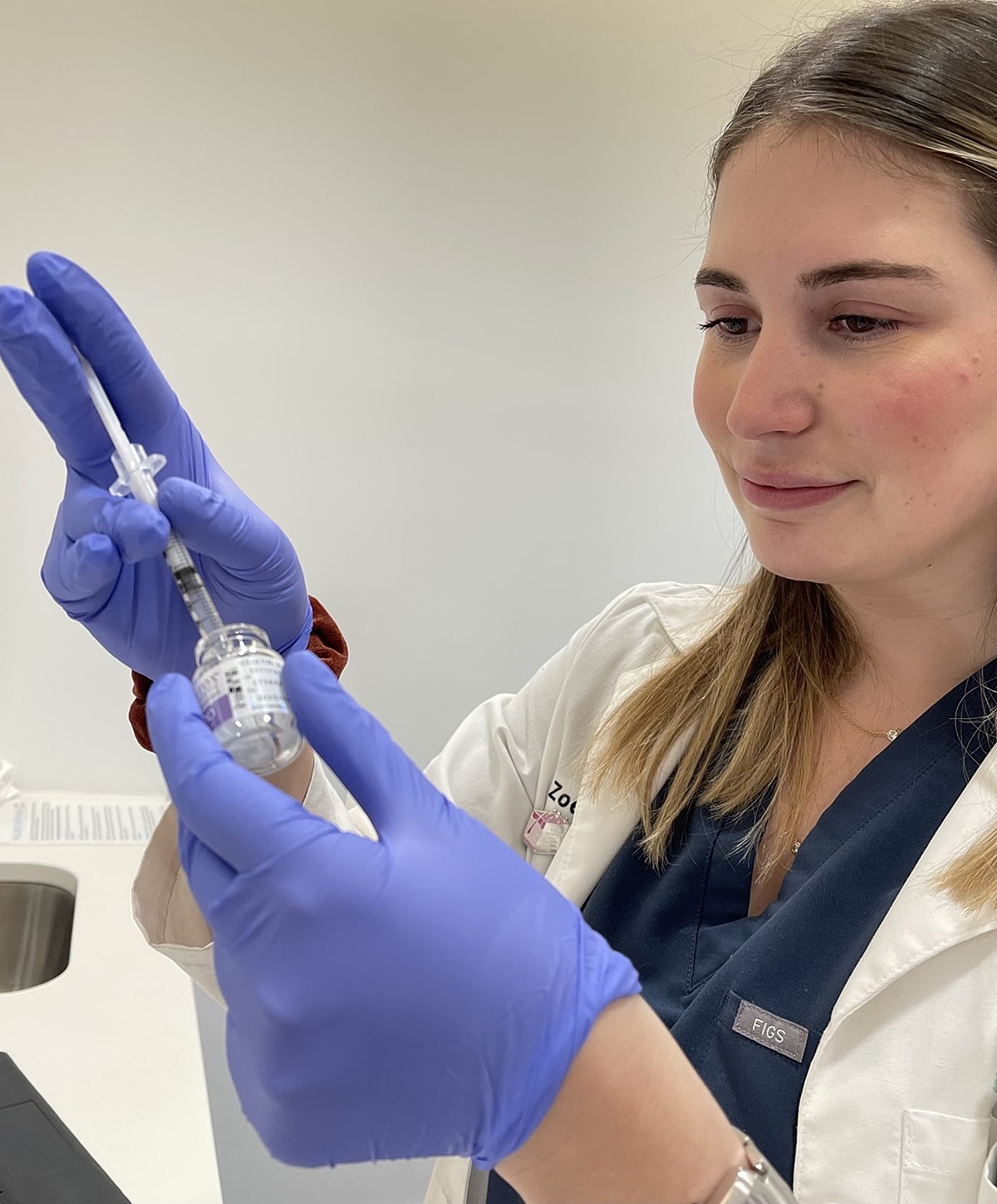 Medical professional preparing a vaccine dosage.