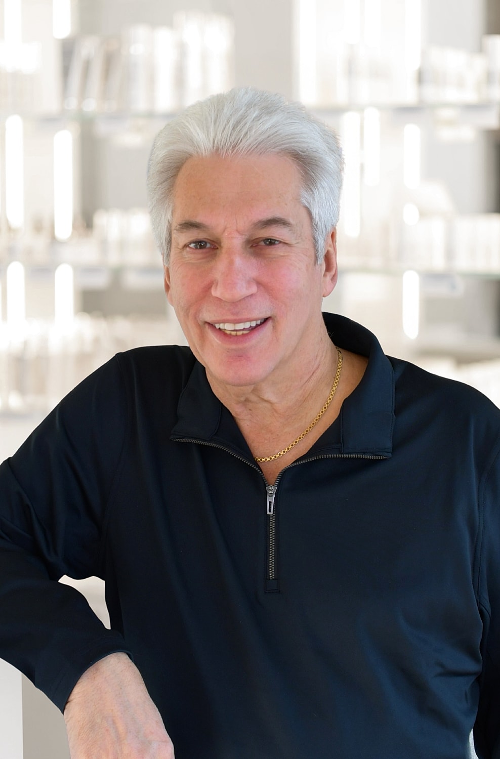 Smiling man in dark jacket, modern background.