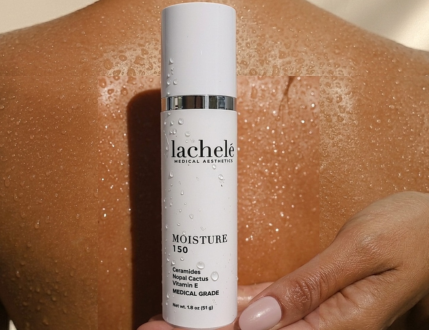 Moisturizer bottle with water droplets on skin.