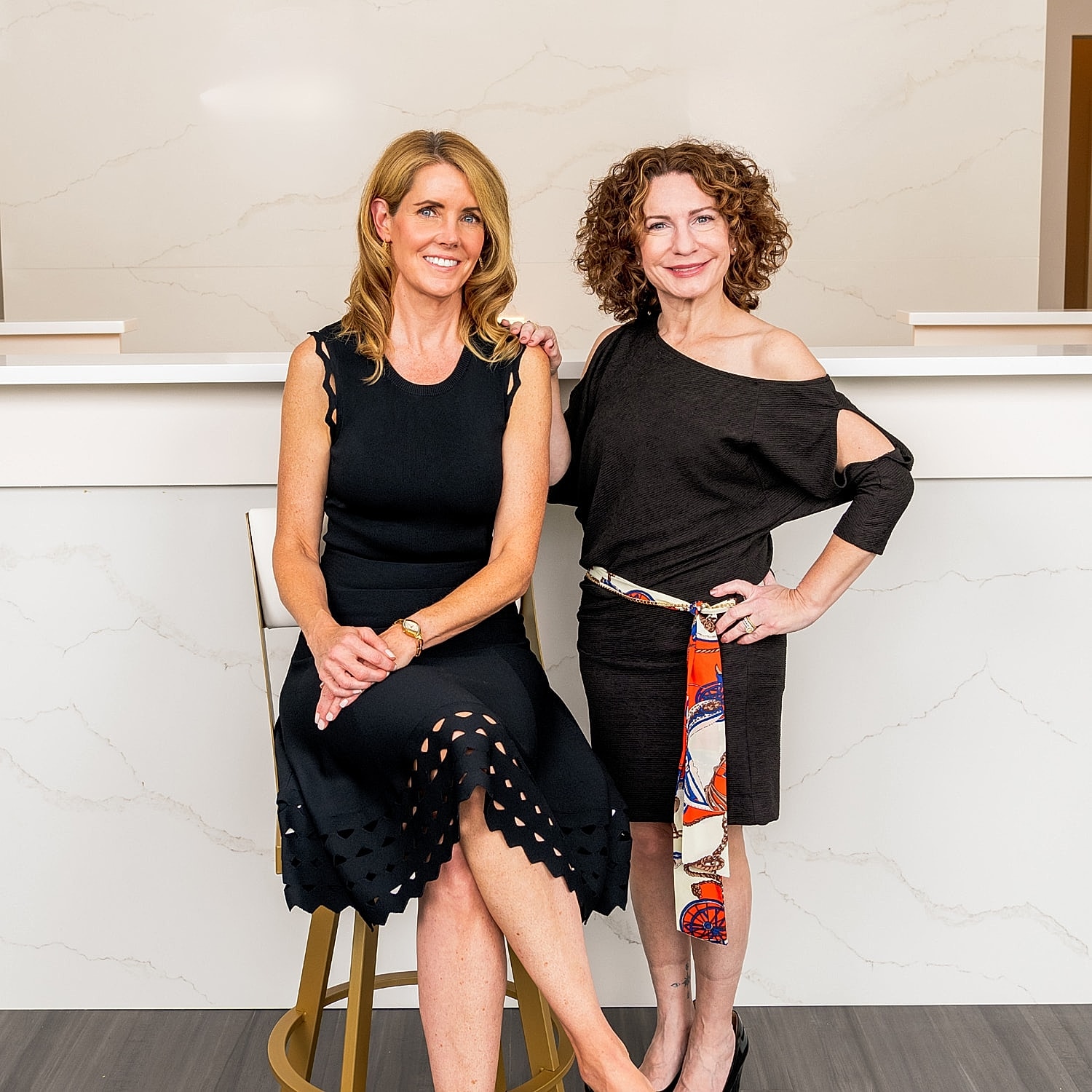 Two women posing in stylish outfits.