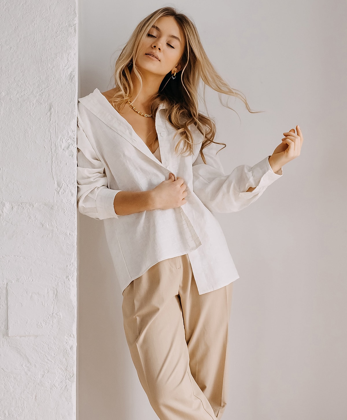 Woman in stylish outfit against a neutral background.