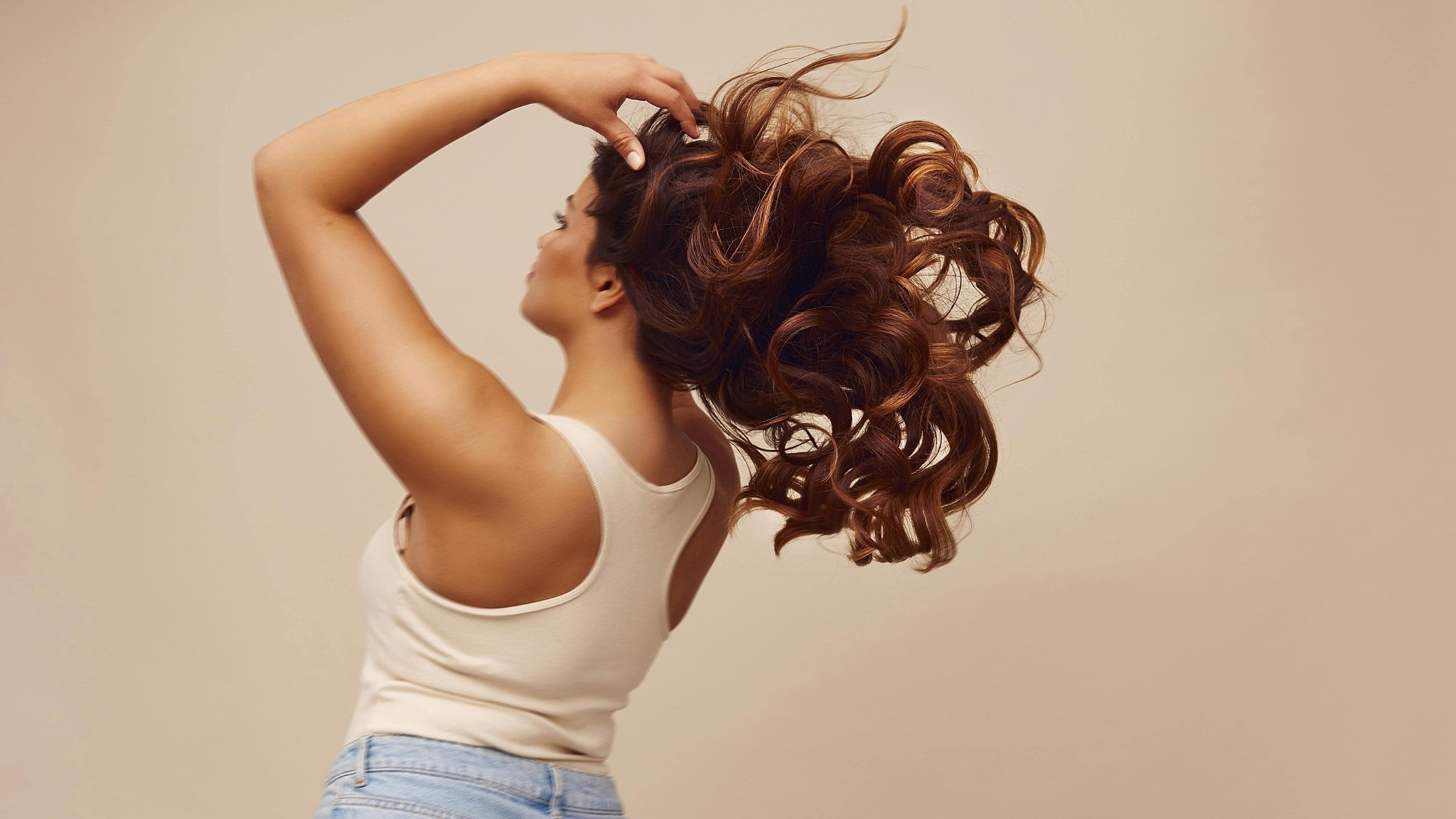 Woman with flowing curly hair in motion.