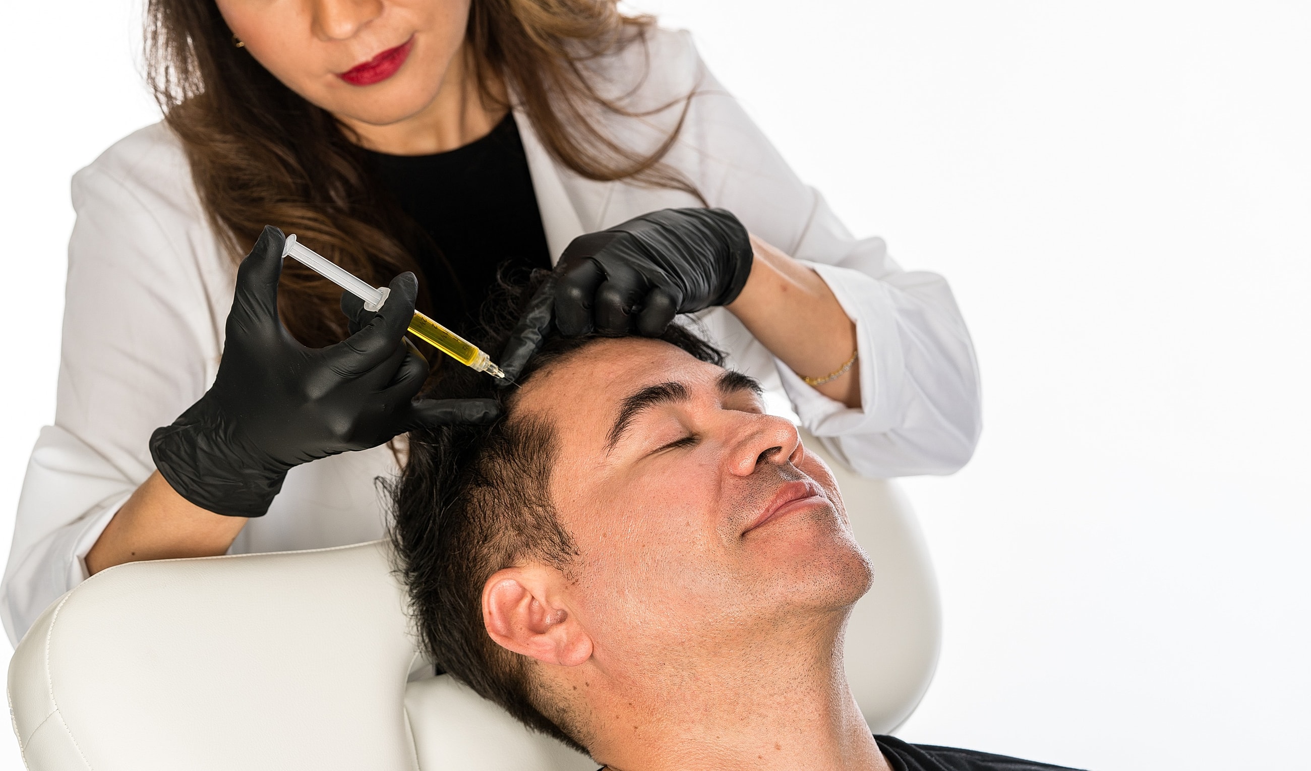 Man in white shirt sitting thoughtfully on couch.