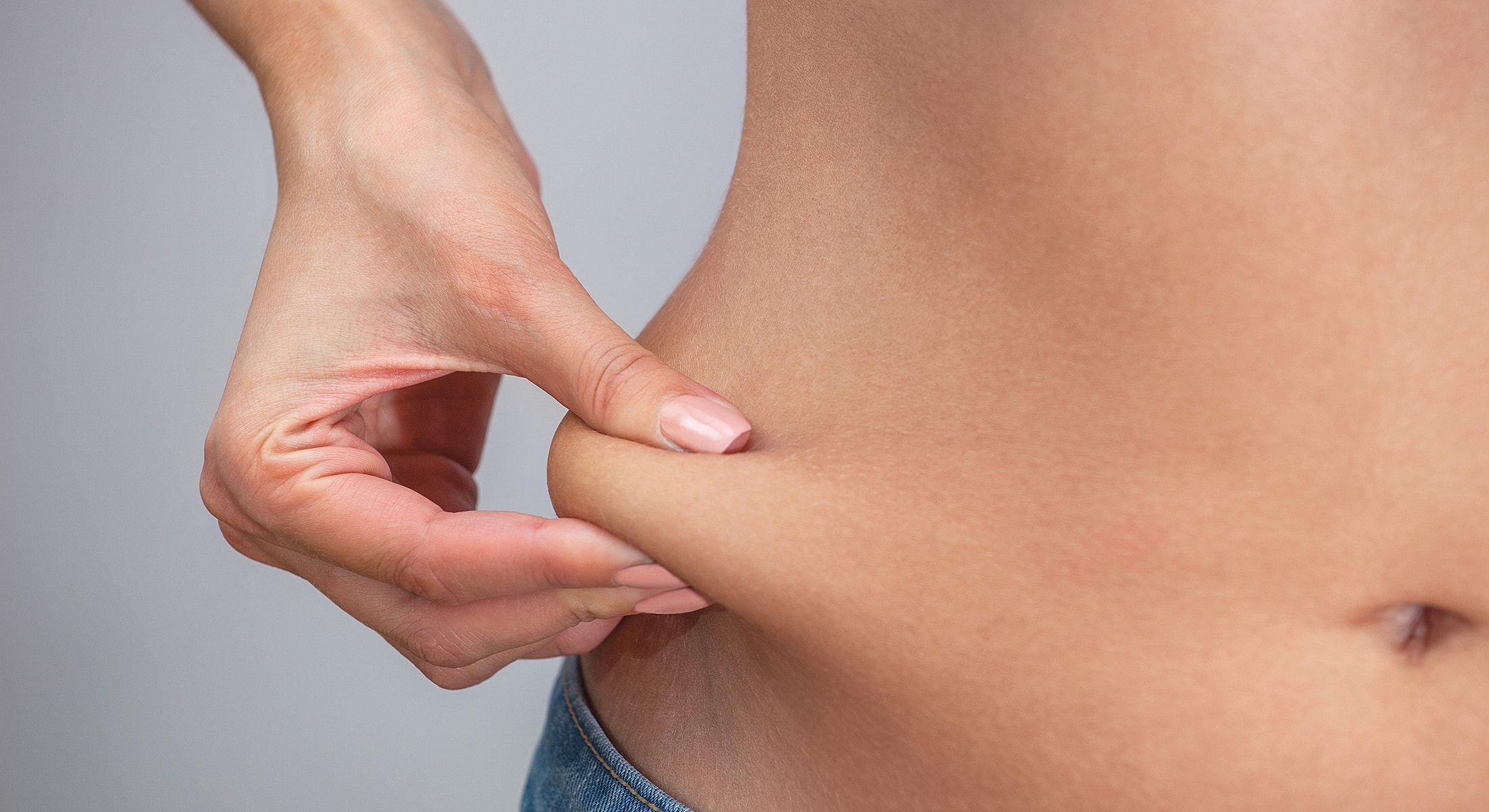 Hand pinching skin on abdomen.
