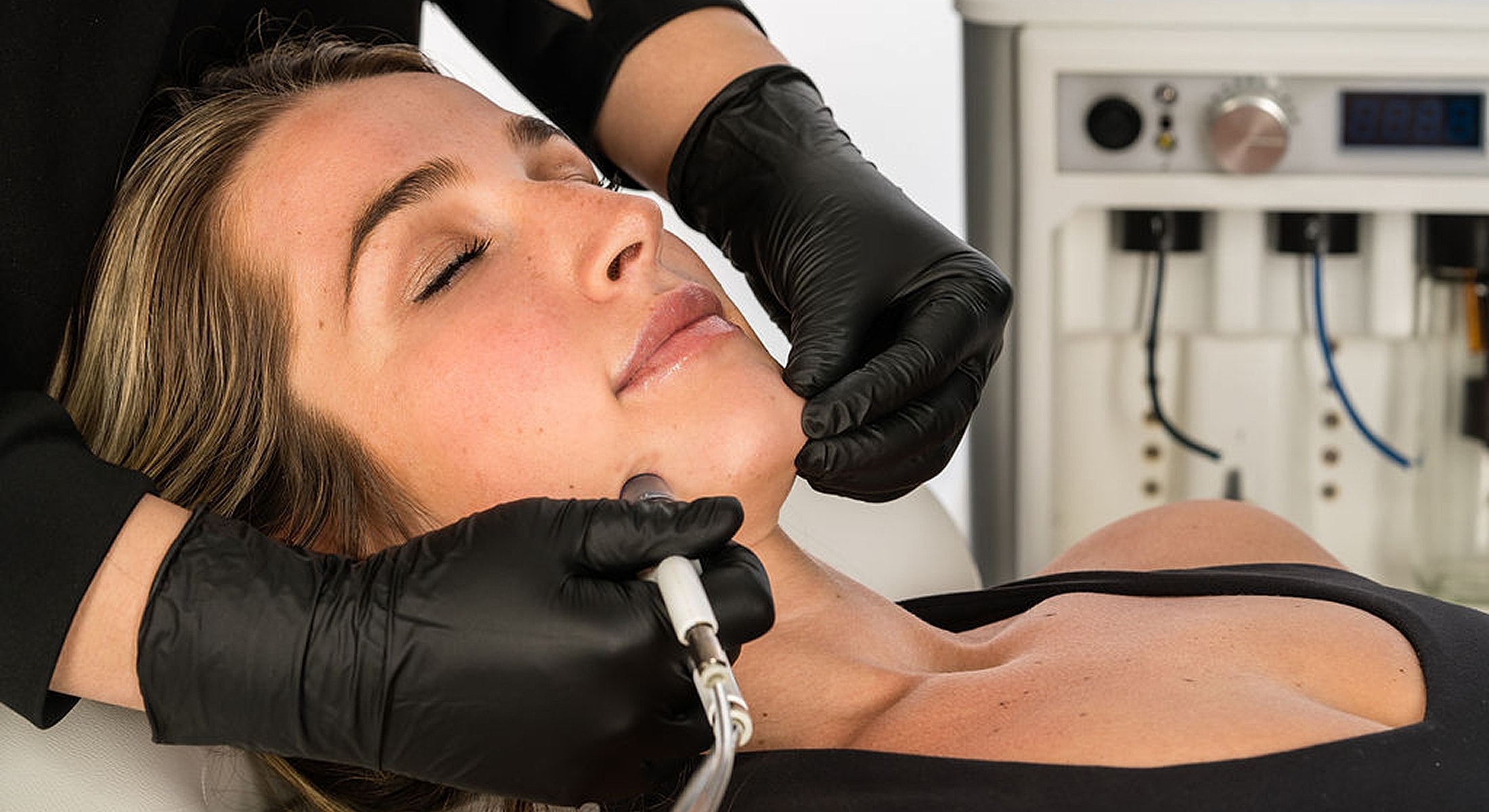 Facial treatment with aesthetic equipment and gloves.