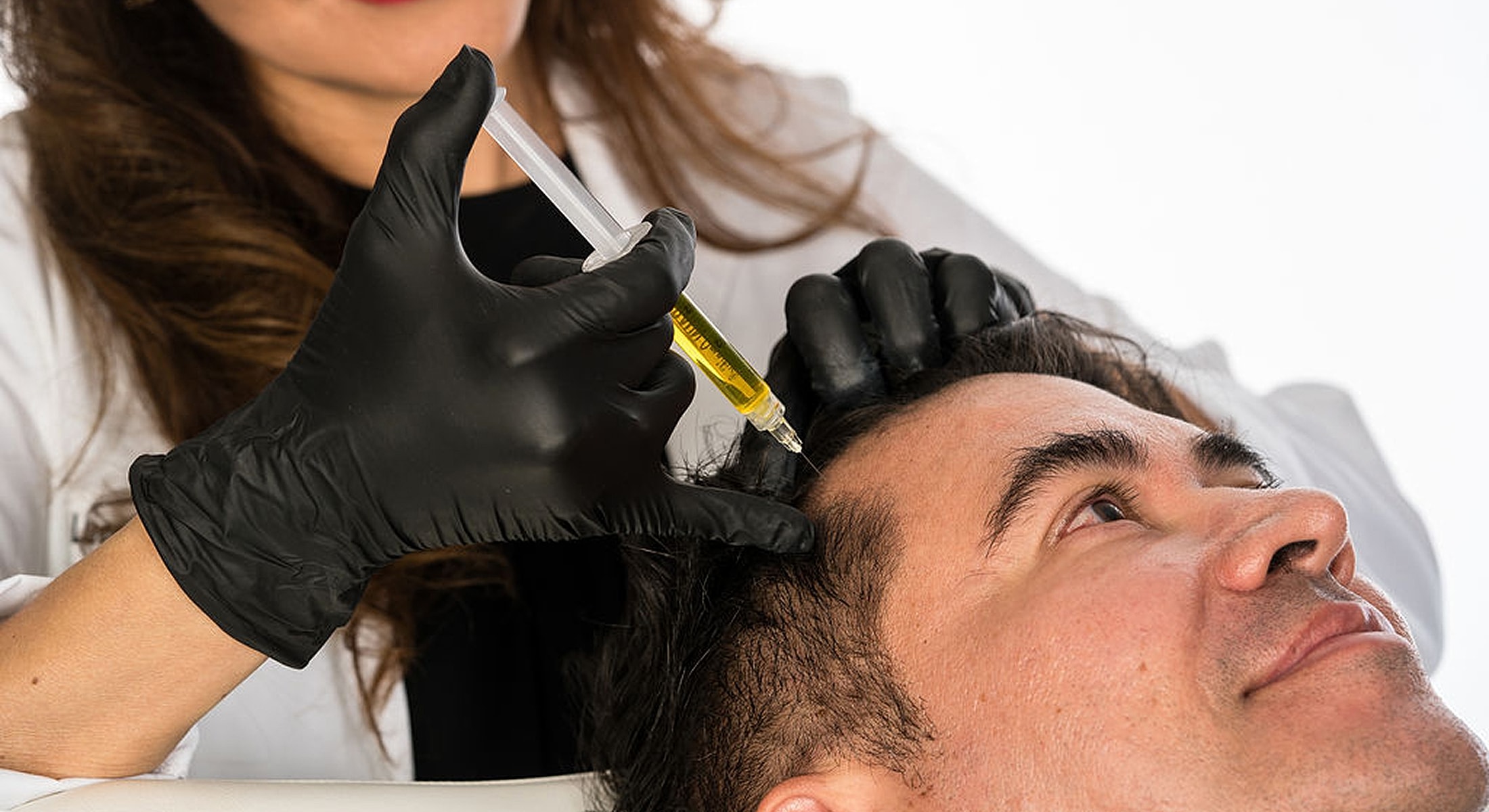 Hair restoration treatment being applied to a patient.