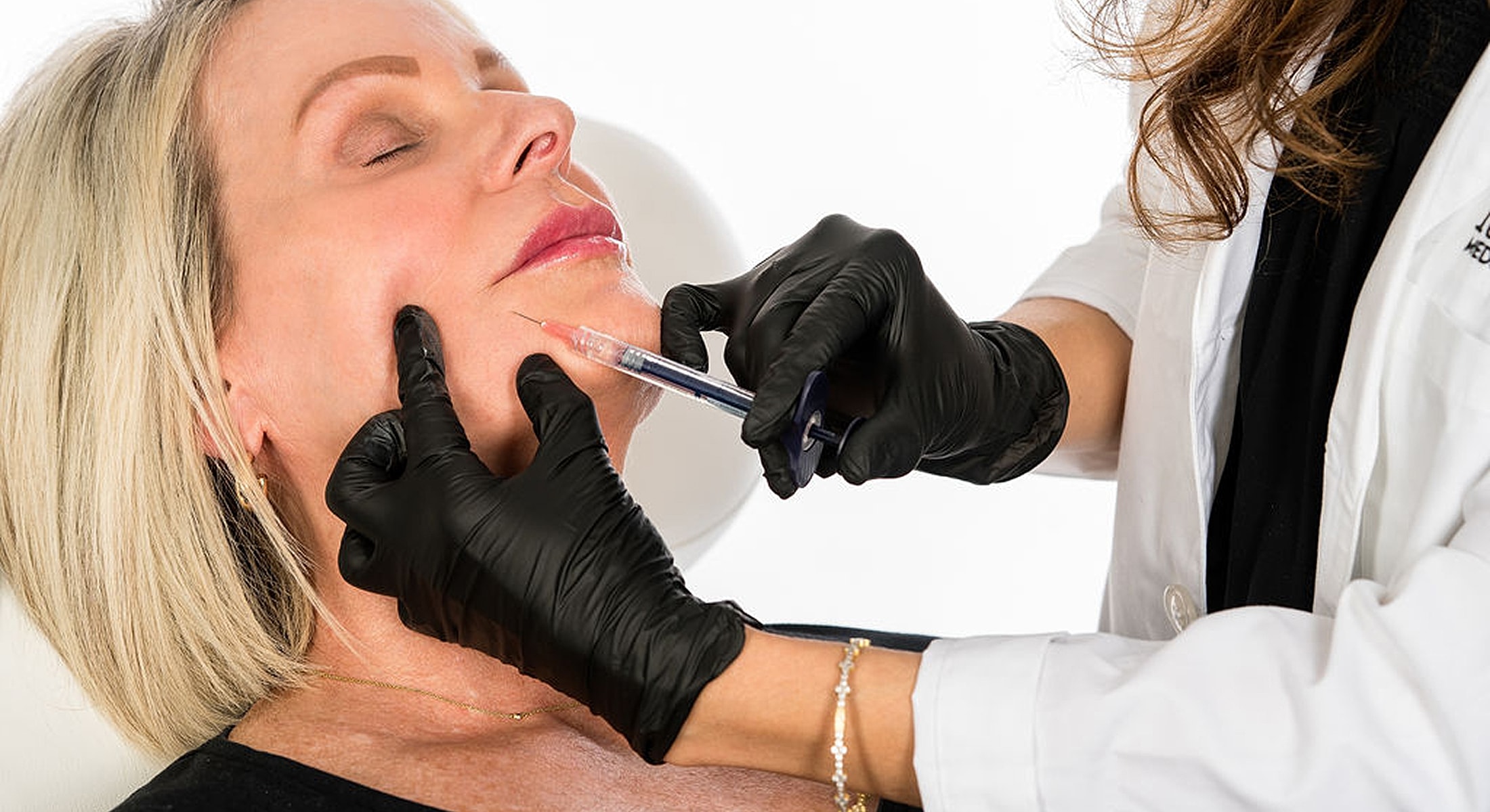 Cosmetic injection procedure on a woman's face.