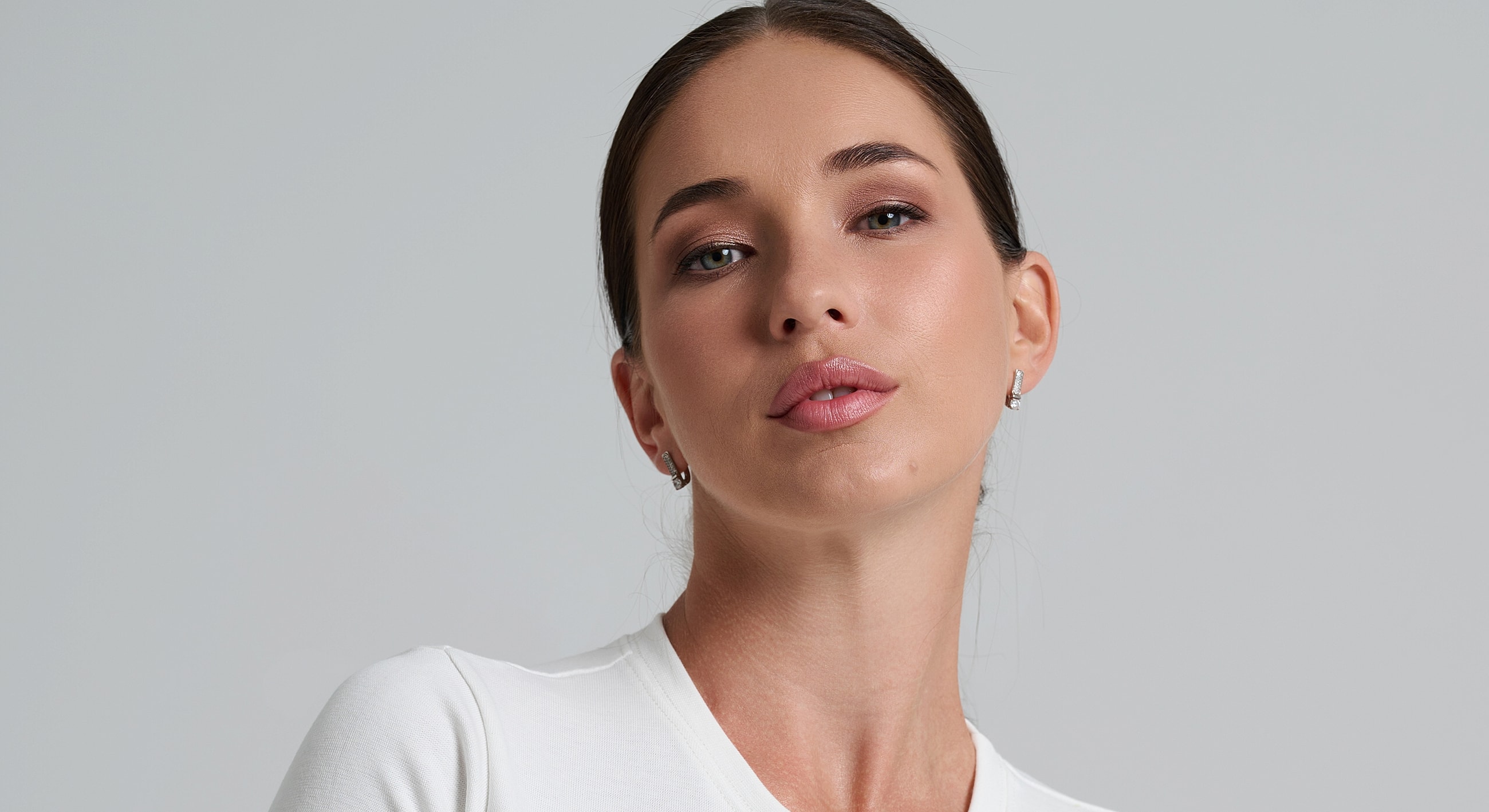 Model with soft makeup and white clothing.