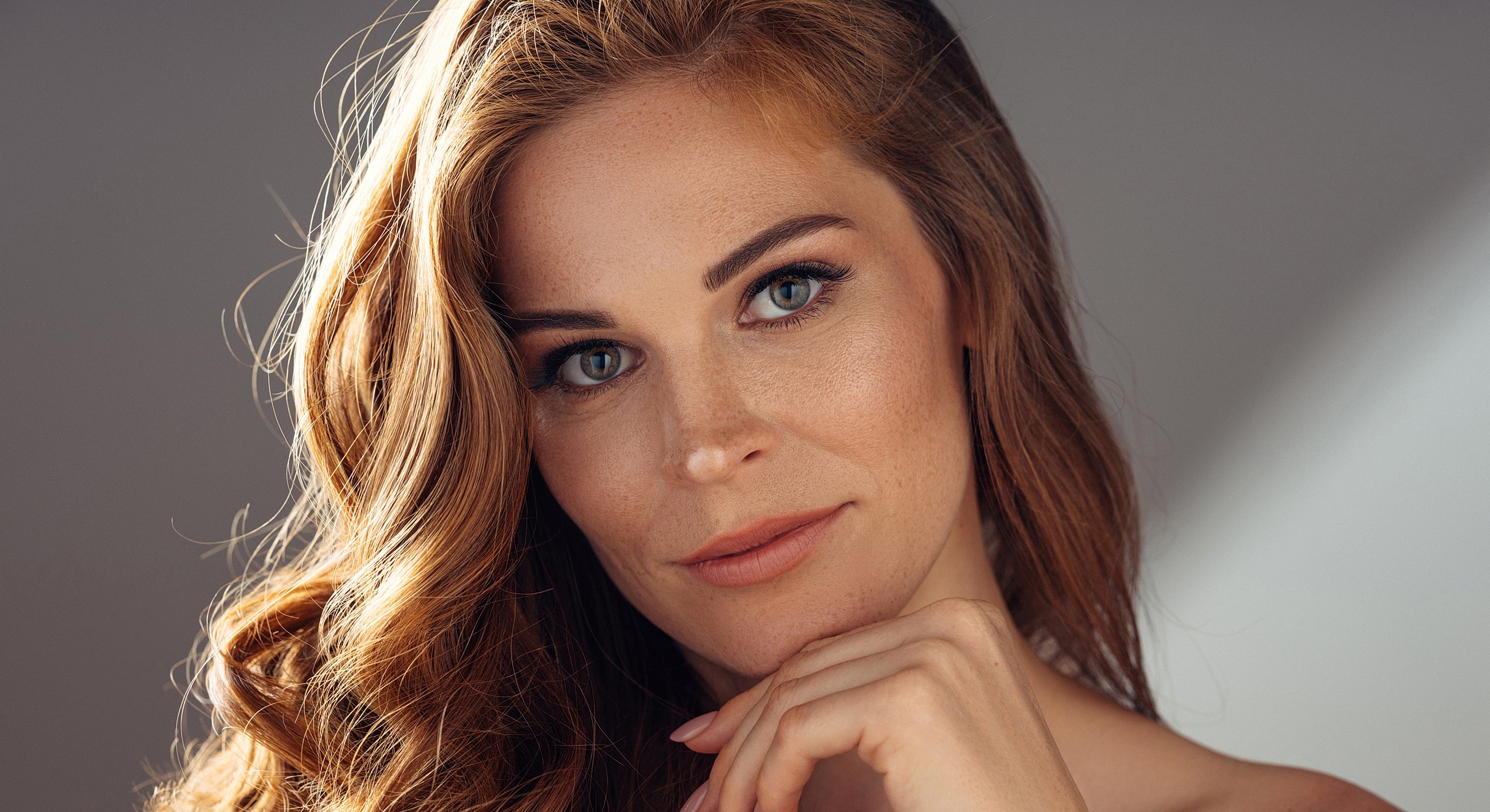 Woman with wavy hair and soft makeup.