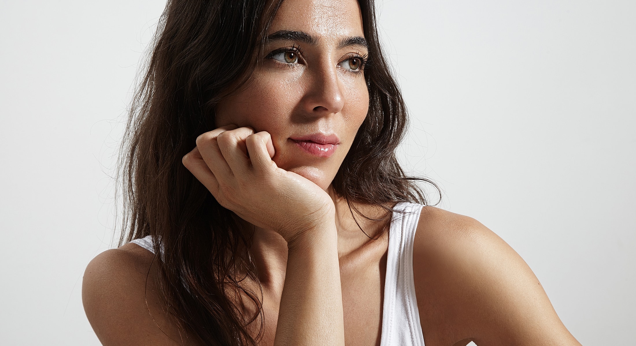 Woman thoughtfully resting her chin on hand.