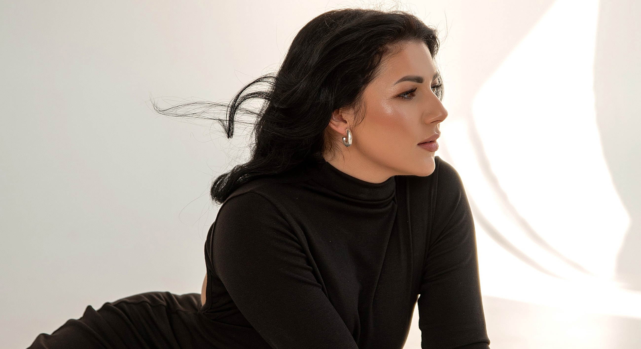 Woman in black outfit with flowing hair.