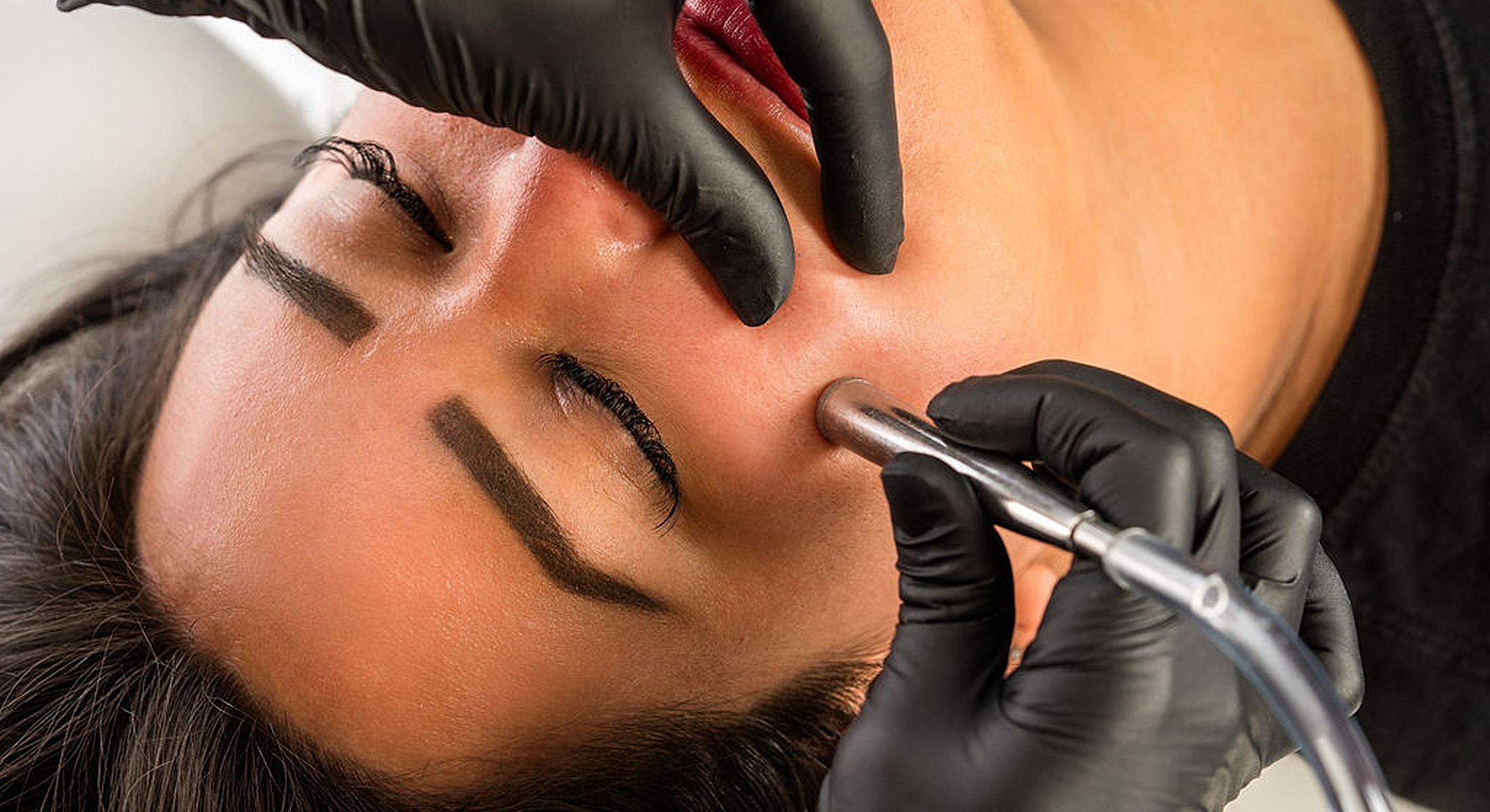 Facial treatment with professional tools and gloves.