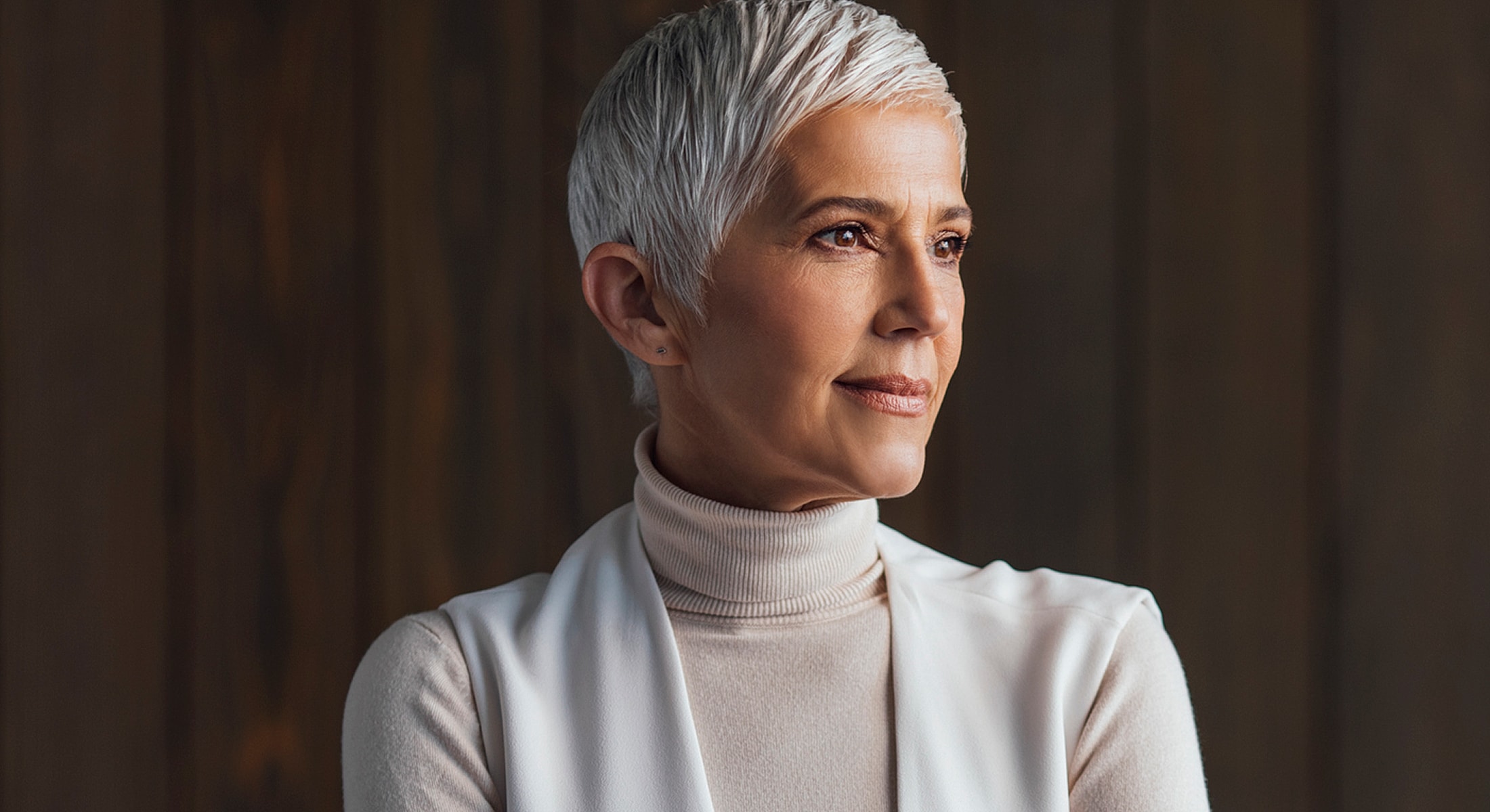 Woman with short gray hair, wearing neutral colors.